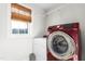 A modern laundry room featuring stainless steel washer, dryer, window, and neutral wall color at 2775 Eagles Roost Trl, Burlington, NC 27217