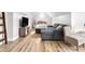 A cozy space with a couch, television, and plush seating area featuring attractive wood flooring at 2775 Eagles Roost Trl, Burlington, NC 27217