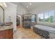 Bathroom featuring a large tub, stone tile, spacious shower, and walk-in closet at 2820 Charleston Oaks Dr, Raleigh, NC 27614