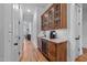 Hallway features a built in bar with granite countertop, wine refrigerator and wooden cabinets at 2820 Charleston Oaks Dr, Raleigh, NC 27614