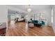 Bright main bedroom boasts wood floors, chandelier, and sitting area with plush green velvet couch at 2820 Charleston Oaks Dr, Raleigh, NC 27614