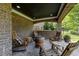 Covered porch with brick and outdoor seating around a barrel fire pit at 2820 Charleston Oaks Dr, Raleigh, NC 27614