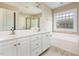 Bathroom features a double sink vanity, a separate shower stall, and a large soaking tub under a frosted window at 300 Sugar Maple Ave, Wake Forest, NC 27587