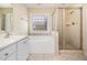 This bathroom features a vanity with a large tub, a separate shower stall, and a frosted glass block window at 300 Sugar Maple Ave, Wake Forest, NC 27587