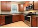 Well-lit kitchen featuring stainless steel appliances, wooden cabinets, and a sink below a window at 300 Sugar Maple Ave, Wake Forest, NC 27587