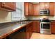 A kitchen featuring stainless steel appliances, wood-stained cabinets, light counters, and laminate flooring at 300 Sugar Maple Ave, Wake Forest, NC 27587