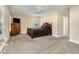A large bedroom featuring neutral walls, soft carpeting, a dark wood bed frame, and two large windows at 300 Sugar Maple Ave, Wake Forest, NC 27587