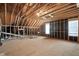 Unfinished attic space with exposed wood beams and one window at 304 Nelson Ln, Clayton, NC 27527