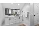 Bathroom with double sink vanity, modern mirror and fixtures, and hardwood flooring at 304 Nelson Ln, Clayton, NC 27527