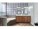 Beautiful bathroom with tiled floors, double vanity, and tub with checked wallpaper accent wall at 304 Nelson Ln, Clayton, NC 27527