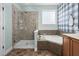 Inviting bathroom with a glass shower, a soaking tub and tiled flooring at 304 Nelson Ln, Clayton, NC 27527