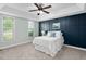 Comfortable bedroom with a tray ceiling, a statement wall and natural light at 304 Nelson Ln, Clayton, NC 27527