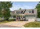 Beautiful home featuring a covered front porch, well-manicured lawn, and attached garage at 304 Nelson Ln, Clayton, NC 27527