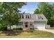 Charming two-story home boasts a quaint front porch, lush lawn, and attached garage at 304 Nelson Ln, Clayton, NC 27527