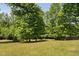 Well-maintained front yard featuring lush green grass and mature trees offering plenty of shade at 304 Nelson Ln, Clayton, NC 27527
