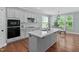 Modern kitchen featuring a large center island, stainless steel appliances, and ample natural light at 304 Nelson Ln, Clayton, NC 27527