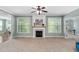 Open-concept living room with large windows, a decorative fireplace and hardwood floors at 304 Nelson Ln, Clayton, NC 27527