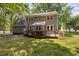 Back of house features a spacious deck, outdoor access and a lush serene backyard at 3113 Chelmshire Ct, Raleigh, NC 27610