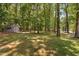 A quiet and serene backyard features a charming shed, mature trees, and lush greenery at 3113 Chelmshire Ct, Raleigh, NC 27610