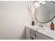 Bathroom features a modern vanity, a round mirror, neutral paint, and decorative elements at 3113 Chelmshire Ct, Raleigh, NC 27610