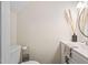 Half bathroom features a modern vanity, a round mirror, neutral paint, and toilet at 3113 Chelmshire Ct, Raleigh, NC 27610