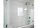 Bright bathroom showcasing a glass-enclosed tub and shower, white tile, and modern fixtures at 3113 Chelmshire Ct, Raleigh, NC 27610