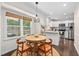 Bright breakfast nook open to the kitchen, featuring a wooden table, chairs, and a sunlit window at 3113 Chelmshire Ct, Raleigh, NC 27610
