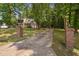 A long driveway leading up to a two-story house surrounded by lush greenery and mature trees at 3113 Chelmshire Ct, Raleigh, NC 27610