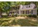Charming two-story home with grey siding, black shutters, a well-manicured lawn and mature trees at 3113 Chelmshire Ct, Raleigh, NC 27610