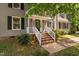 Inviting front entrance with brick steps, white railings, and a black front door and trimmed bushes at 3113 Chelmshire Ct, Raleigh, NC 27610