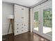 A spacious living area featuring a classic built-in, wood floors and glass paned door to the deck at 3113 Chelmshire Ct, Raleigh, NC 27610