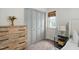 Charming bedroom showcasing natural wood dresser, closet with gray doors, a woven blind and a neutral color scheme at 3113 Chelmshire Ct, Raleigh, NC 27610