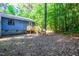 Backyard view of the deck with stairs to the back yard area with mature trees at 327 Woodbridge Dr, Chapel Hill, NC 27516