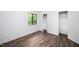 Bright bedroom features new dark floors, a window, and double door closet at 327 Woodbridge Dr, Chapel Hill, NC 27516