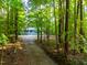 View of home down wooded driveway at 327 Woodbridge Dr, Chapel Hill, NC 27516