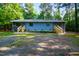 Exterior view of a blue duplex featuring two entrances, wooden decks, and gravel yard at 327 Woodbridge Dr, Chapel Hill, NC 27516