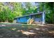 Blue home with wood stairs surrounded by trees and grass at 327 Woodbridge Dr, Chapel Hill, NC 27516