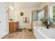 Bright bathroom features a soaking tub, glass shower, and vanity with a large mirror at 3633 Willow Stone Ln, Wake Forest, NC 27587