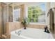 Bright bathroom featuring a soaking tub, tiled walls, and a shower with glass door at 3633 Willow Stone Ln, Wake Forest, NC 27587