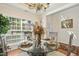 Elegant dining room with a glass table, chandelier, and large window, perfect for gatherings at 3633 Willow Stone Ln, Wake Forest, NC 27587