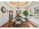 Elegant dining room with a glass table, chandelier, and large window, perfect for gatherings at 3633 Willow Stone Ln, Wake Forest, NC 27587