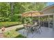 Outdoor patio area with a table, chairs, umbrella, and a serene garden view at 3633 Willow Stone Ln, Wake Forest, NC 27587