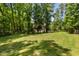 Large, grassy backyard surrounded by mature trees and a rustic wooden fence offers privacy at 3650 Brooks Bnd, Franklinton, NC 27525
