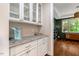 Butler's pantry with elegant cabinetry, granite countertops, and stylish glass display shelves at 3650 Brooks Bnd, Franklinton, NC 27525
