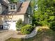 Close up of a two-car garage surrounded by lush landscaping and a beautiful bay window at 3650 Brooks Bnd, Franklinton, NC 27525