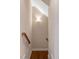 Well-lit hallway with hardwood floors and a wooden banister, providing an inviting transition between living spaces at 3650 Brooks Bnd, Franklinton, NC 27525