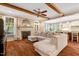 Open-concept living room featuring wood beams, hardwood floors, fireplace, and seamless access to the kitchen and dining area at 3650 Brooks Bnd, Franklinton, NC 27525