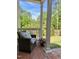 A cozy outdoor brick porch and chair, next to a house with a green lawn at 3838 Regent Rd, Durham, NC 27707