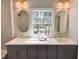 Elegant bathroom with double vanity, modern fixtures, and a large window offering serene outdoor views at 3838 Regent Rd, Durham, NC 27707