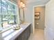 Well-lit bathroom featuring a single vanity, quartz countertop, and large window for ample natural light at 3838 Regent Rd, Durham, NC 27707